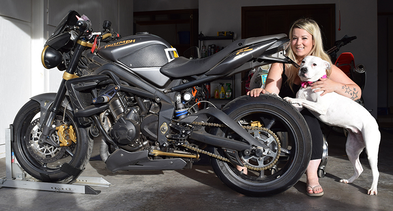 Brittney and her pup, Shawty (“Shorty” with a southern twang), tackle DIY motorcycle maintenance in their own garage together.