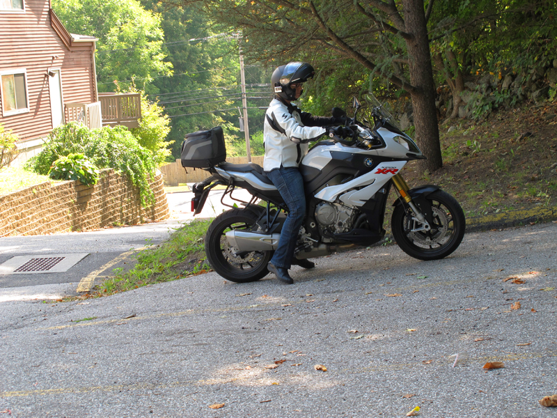 If the parking space goes uphill, I’ll park front wheel in first. Then, when I’m ready to leave, I can just back it out of the spot. Make sure you always leave the bike parked in gear so it doesn’t roll.