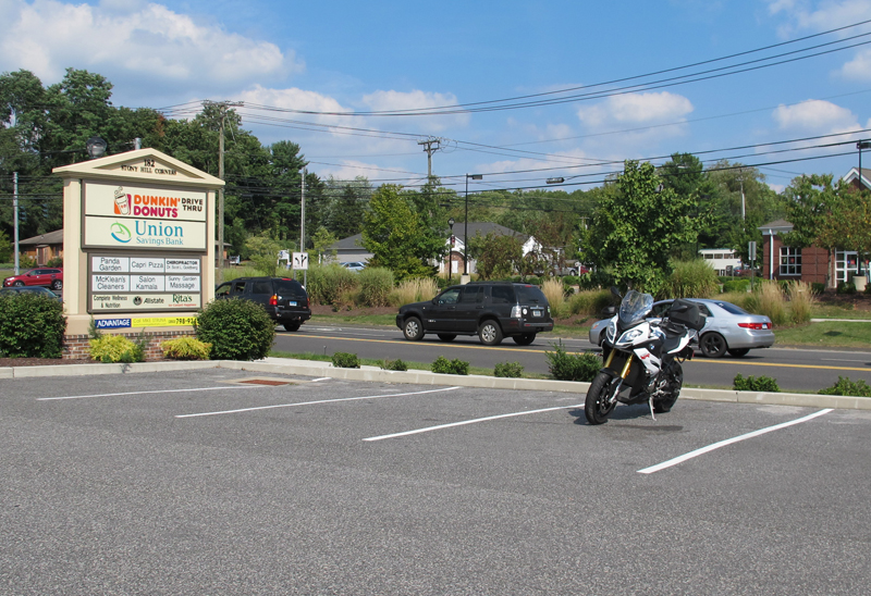 Parking on a level surface is easier, but you may need to back the bike into the spot. Of course, a level spot that you can ride into and out of is best. Always seek these out first. Make sure there’s no way someone can come along and park right in front of your motorcycle if you were planning to ride it out. If you’re parking in a spot with a cement bumper, but there’s room to the left and right to ride out, position the bike far enough away from it so it’ll be easy to ride around it when you leave.