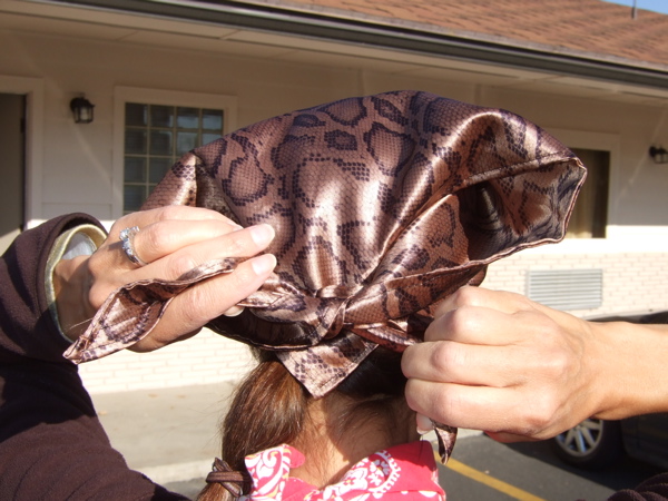 Tying the loose ends of the scarf. There's plenty to work with unlike a bandanna where the ends are usually really short when wearing it on your head. I'm wearing the brown/black snake bike color pattern scarf.