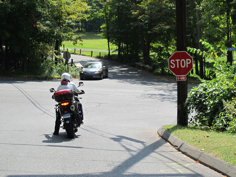 If you can reach the ground with tiptoes, you can then keep the front brake applied while you put your right foot down too. And always keep the handlebar squared off when you come to a stop, or else the motorcycle will want to fall in the direction they are turned.