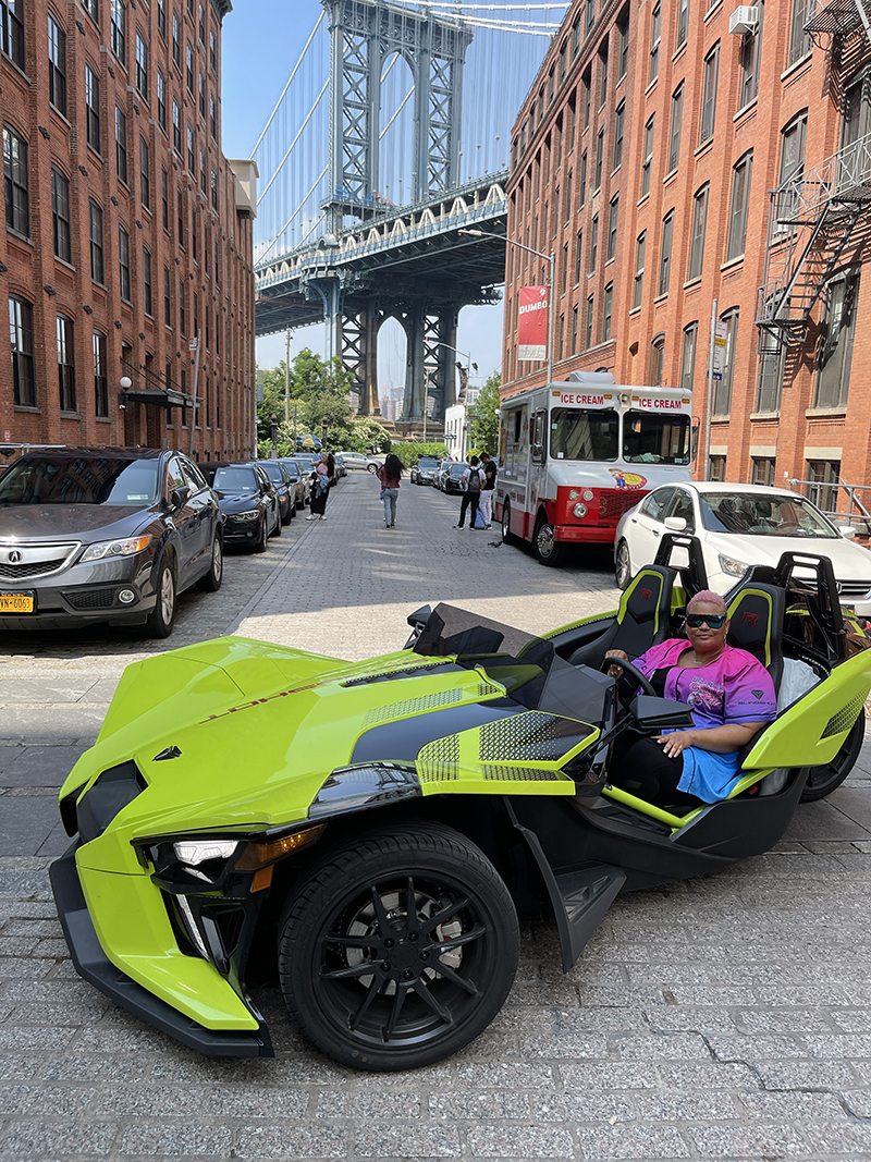 Porsche with "Limelight," her new 2021 Slingshot R LE with manual transmission. She says, "With it's cool Neon Fade asymmetrical paint and graphics, blacked out badges, black rims, and matching interior, I didn't need to do much to make it a head turner."