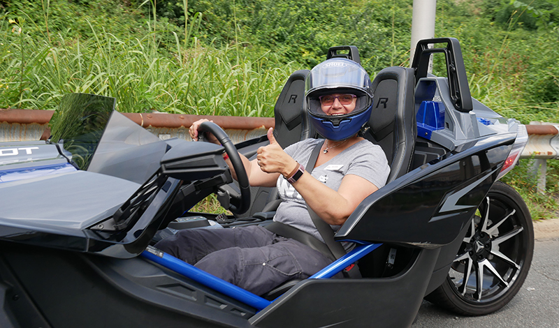 Tricia enjoys all the perks of open air riding while aboard the Slingshot, as well as its convenience features like lockable storage, GPS, backup camera, and a great sound system.