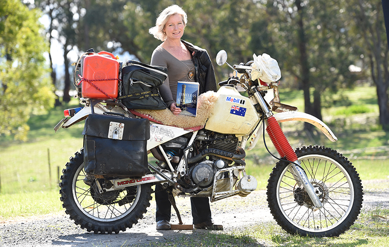 Author Heather Ellis with her book, <i>Timeless On The Silk Road</i> and her Yamaha TT600 motorcycle. Photo by Lawrence Pinder