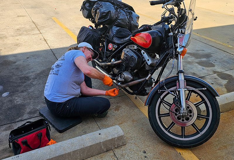 woman wrenching vintage bike