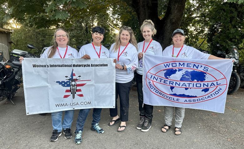 Canadian and American WIMA members proudly display the WIMA USA and WIMA International banners—representing just a few of the many countries already onboard for the next global WRWR mission. With ambassadors stepping up from across the world, the team is still calling on women riders everywhere to help carry the torch and represent their countries in this growing international sisterhood.