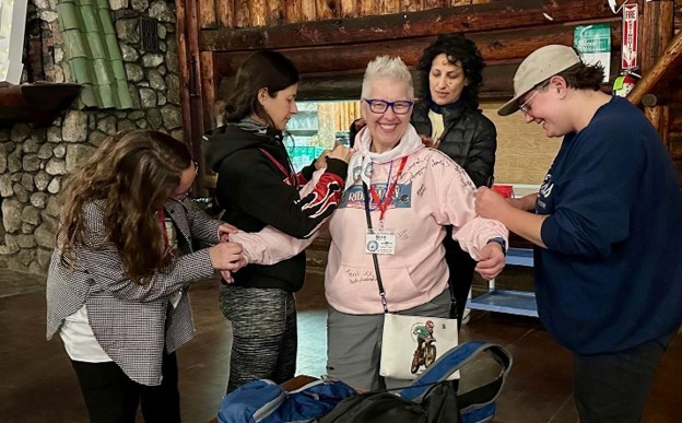 Picture18 WIMA members sign Ruth’s Ride4Mary sweatshirt.We also signed each other’s gear—like my Ride4Mary sweatshirt—leaving our mark on each other in ink, spirit, and solidarity.
